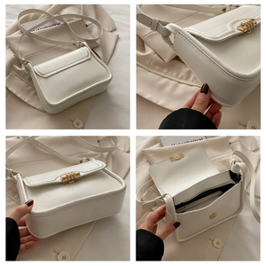 Close-up of cream shoulder bag featuring gold hardware and striped twist lock detail
