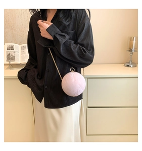 Detailed view of pink spherical chain bag with golden ring handle and pleated texture