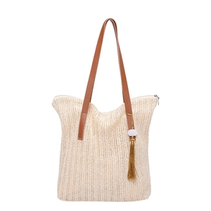 Large beige woven straw tote bag with brown handles and beaded tassel for summer vacation