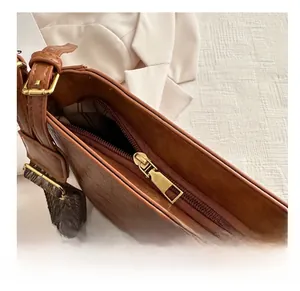 Détail du zip doré et de la doublure à carreaux sur un sac seau en cuir marron vintage