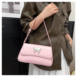 Detailaufnahme der rosa Umhängetasche mit silberner Schmetterlingsschnalle und Kettenriemen