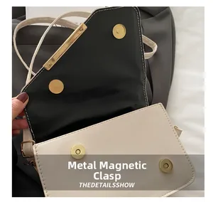 Detail of the high-quality gold metal magnetic buckle closure on a stylish crossbody bag