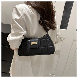 Vista lateral del bolso baguette negro acolchado con hebilla dorada al hombro