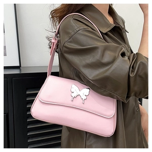 Nahaufnahme einer rosa Schultertasche mit silbernem Schmetterling im modernen Y2K-Stil