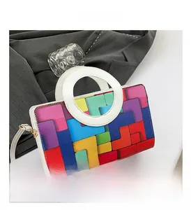 Close-up of colorful geometric pattern and white circular handle on a stylish handbag