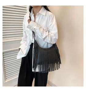 Détail du sac hobo bohème en cuir noir avec de longues franges élégantes et une bandoulière