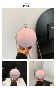 Detail of pink spherical evening bag featuring crinkled texture and gold metal ring handle