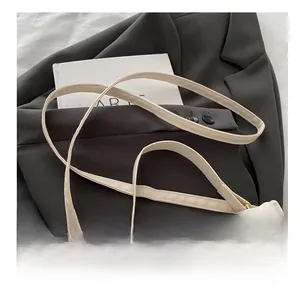 Detail of white quilted crossbody bag showing fine stitching and gold metal buckle