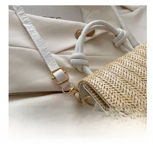 Detailed view of adjustable golden buckle on white leather and woven strap