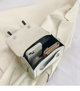 Interior view of off-white leather shoulder bag showing storage for phone and wallet