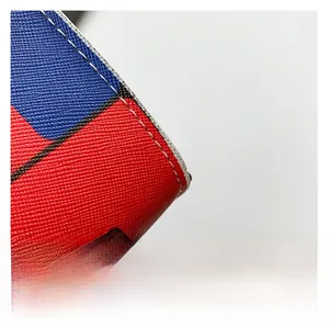 Macro detail of cross-grain textured leather with contrast red and blue stitching