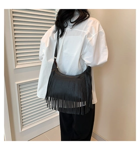 Détail du sac à bandoulière en similicuir noir avec de longues franges et silhouette hobo