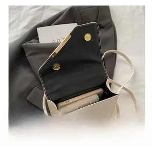 Detail view of the spacious inner compartment of the beige quilted crossbody bag