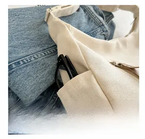 Close-up of canvas tote side pocket featuring a practical storage space for glasses
