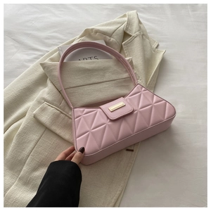 Detailed texture of pink quilted baguette bag with gold metal rectangle twist lock