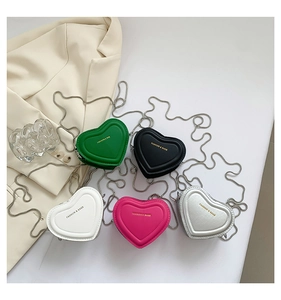 Flat lay of heart-shaped mini bags in five colors with metallic chain shoulder straps