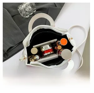 Top view of the white bag interior showing storage space for phone and makeup items