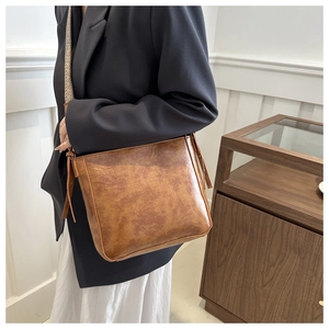 Close-up of vintage brown bucket bag featuring a stylish jacquard woven wide shoulder strap