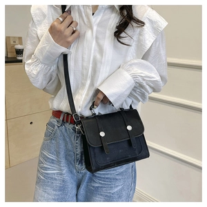 Fashionable black matte crossbody bag worn by a model in a casual daily outfit