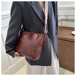 Détail du sac bandoulière vintage en cuir huilé marron avec une large sangle élégante