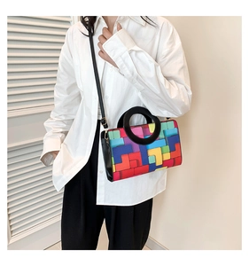Fashionable colorful geometric block print handbag with black ring handle and shoulder strap