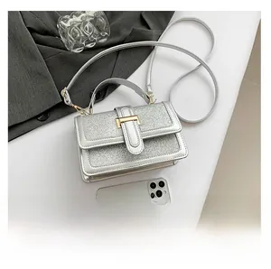Detailed view of a silver sequin crossbody bag featuring a metal clasp and shimmering texture
