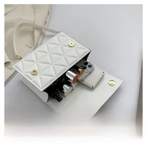 Top-down view of white quilted crossbody bag showing internal storage for phone and lipstick
