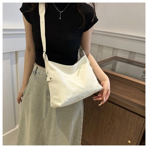 Detail of white large hobo bag with matte pleated texture and adjustable wide shoulder strap