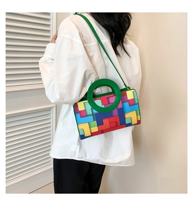 Detail of trendy crossbody bag featuring colorful geometric patterns and green round handle