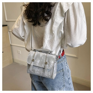 Detail of silver vintage texture small square bag with metallic buckle and shoulder strap