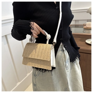 Straw mini square bag with contrast leather trim worn as a stylish crossbody purse