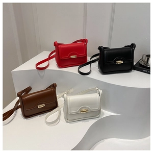 Close-up of four colors of stylish small square bags with golden cylindrical metal locks