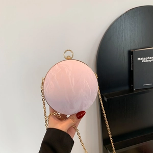 Elegant pink shell-textured spherical evening bag with gold ring handle and chain strap