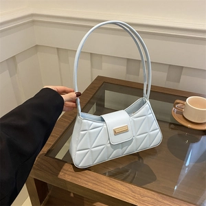 Light blue quilted baguette bag with geometric patterns and elegant gold buckle