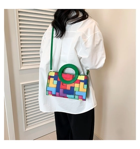 Detail of colorful geometric block print shoulder bag with green circular handle