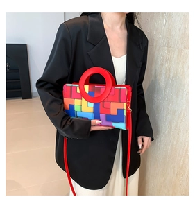 Artistic geometric patchwork handbag with red circular handle and colorful square patterns
