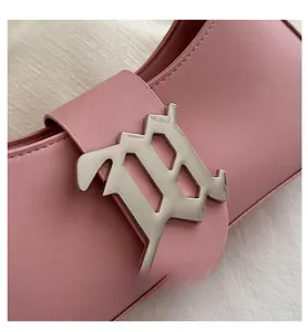 Detail of light pink leather shoulder bag featuring a gothic style silver metal buckle