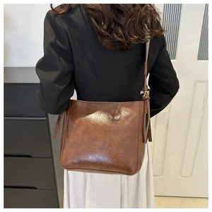Detail view of large brown vintage bucket bag with bohemian print shoulder strap