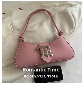 Pink matte leather baguette bag with metal M logo and phone for size reference