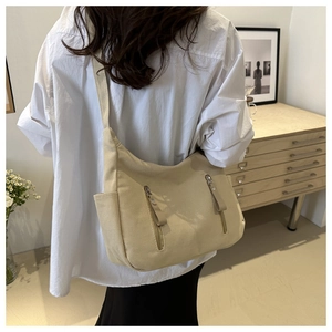 Detail view of large cream canvas tote bag with functional vertical zipper pockets
