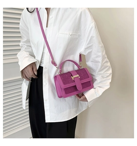 Detail of rose red sequined crossbody bag with gold metal buckle on white shirt
