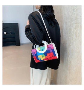 Detail showing white handbag with colorful tetris geometric pattern and round handles