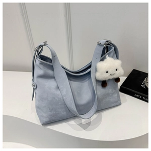 Minimalist light blue crescent crossbody bag with plush cloud charm and wide strap