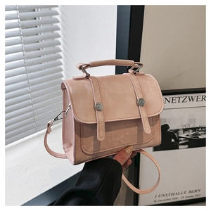 Detailed view of a pink retro crossbody bag with silver rivets and matte texture finish