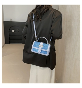 Detailed view of sky blue sequin crossbody bag styled with a professional black blazer