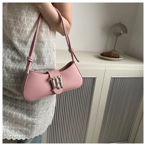 Detail of pink shoulder bag featuring silver gothic M buckle and knotted strap detail