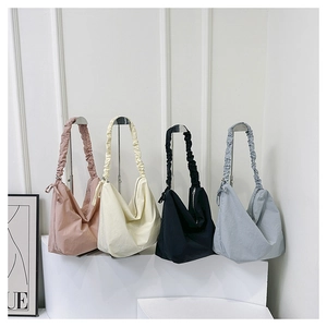 Four large nylon hobo bags in pink, beige, black, and blue with ruched shoulder straps