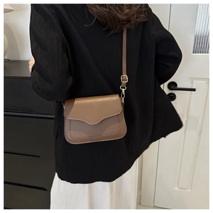 Detail of a brown minimalist crossbody bag showing its elegant flap and stitching