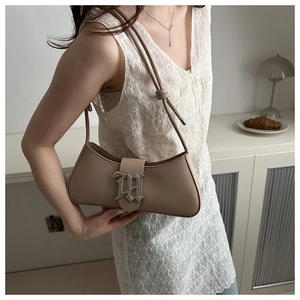 Detail of beige underarm bag with gothic metal buckle on white lace outfit