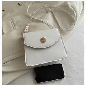 Sac trapèze blanc avec boucle dorée et smartphone pour comparaison de la taille